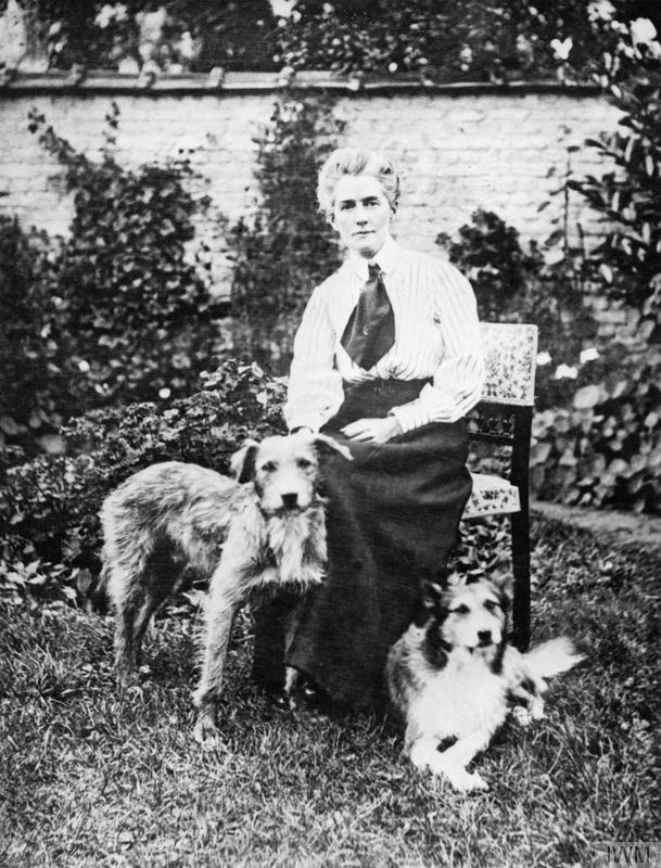Pre-War Life in Brussels - A portrait of nurse Edith Cavell as she sits in a garden her two dogs. The dog on the right, "Jack" was rescued after her execution. - © IWM Q 32930